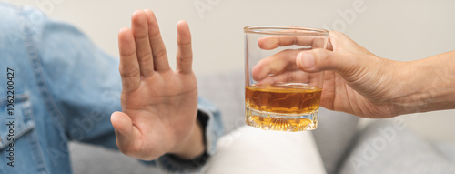 Photos Alcoholism, depressed asian young man refuse, push out alcoholic beverage glass, drink whiskey, sitting alone at night