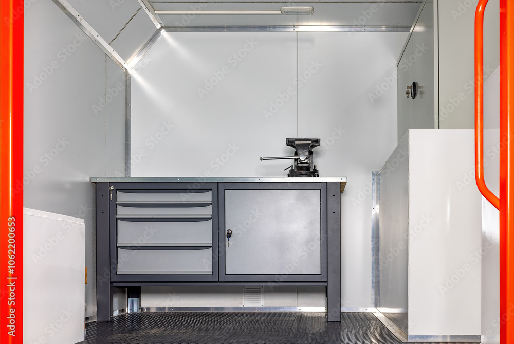 Interior of a modern truck-based mobile workshop with a gray workbench, elegant design, practical workspace concept.