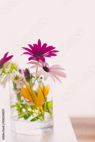 Close-up of assorted colourful flowers in a glass on a table photo