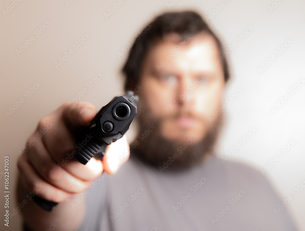Man Aiming Gun Directly at the Camera for Dramatic Effect Man Aiming Gun Directly at the Camera for Dramatic Effect