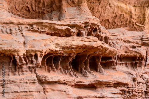 Close-up of bizarre sandstone formations, rough surfaces, curved lines, and erosion marks. The shapes resemble abstract art, with curves and edges shaped by the wind. photo