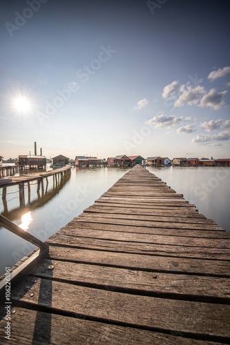 Wooden houses in the water. Holiday resort in the lake at sunset. Long wooden walkways lead to the individual houses. Landscape photo of the floating village of Bokodi, Lake Balaton, Hungary