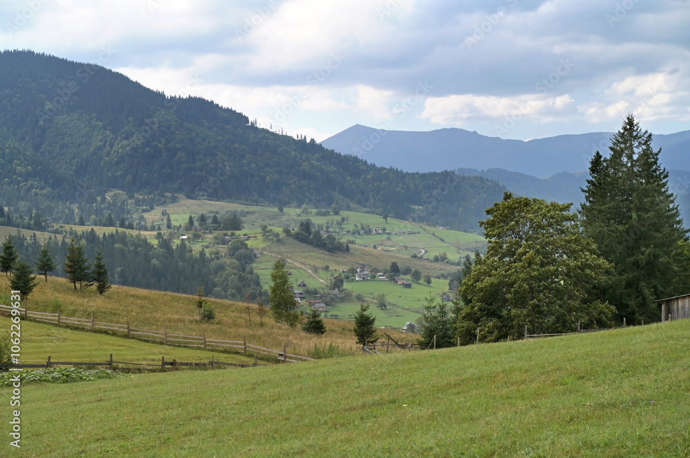 Mountain landscape with village and a green pasture in the foreground. Mountain landscape with village and a green pasture in the foreground.
