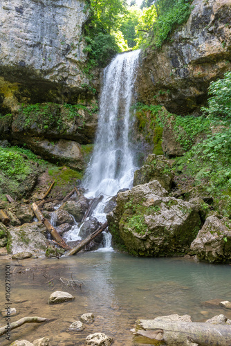 a waterfall in the summer, rushing streams and jets of water and turned into a huge shower of water