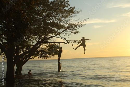 silhueta de crianças não identificadas brincando no rio tapajós, em belterra, pará 