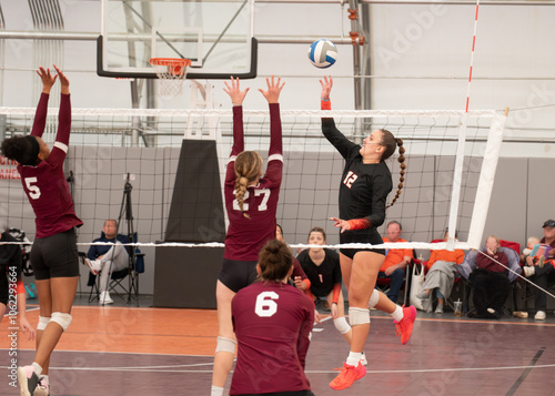 Volleyball player dinking the ball during college sixes match photo