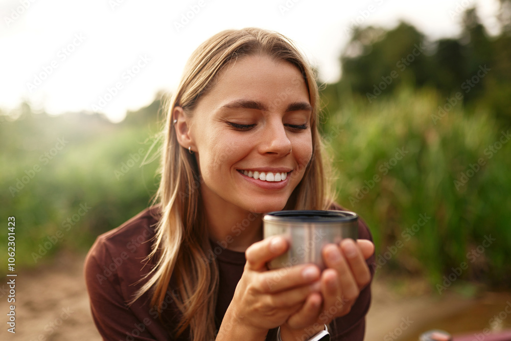 A Young Woman Happily Enjoys a Warm Drink While Surrounded by Beautiful Nature Scenery A Young Woman Happily Enjoys a Warm Drink While Surrounded by Beautiful Nature Scenery