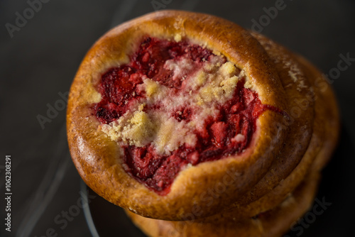 Close-Up of Traditional Czech and Slovak Kolach Pastry with Strawberry Filling on Black Background