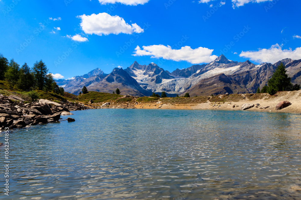 View of Grunsee lake (Green Lake) and the Swiss Alps at summer on the Five Lakes Trail in Zermatt, Switzerland View of Grunsee lake (Green Lake) and the Swiss Alps at summer on the Five Lakes Trail in Zermatt, Switzerland
