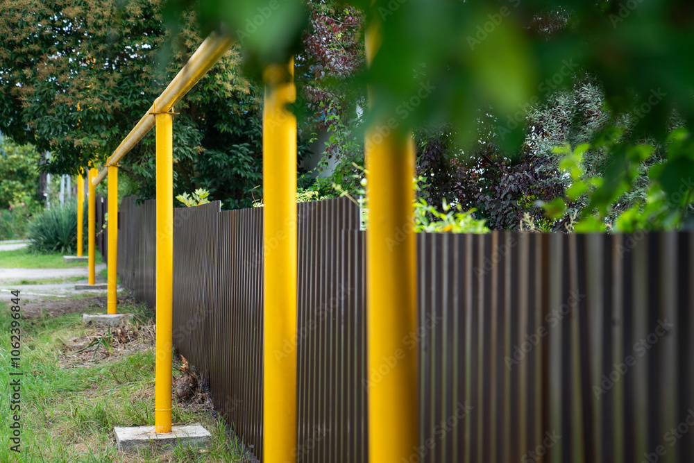 Fototapeta premium Household gas. Gas connection to houses. Gasification of residential buildings. Yellow gas pipe along residential buildings.