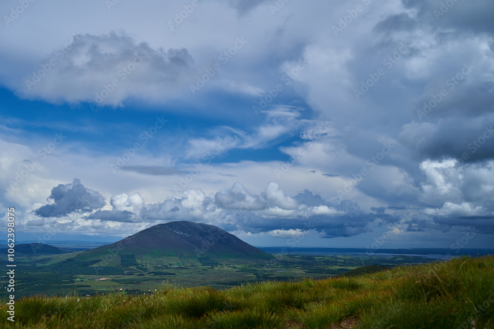 Cumulus or cluster clouds moving over a field with blue sky background in sunny weather in a wide angle shot