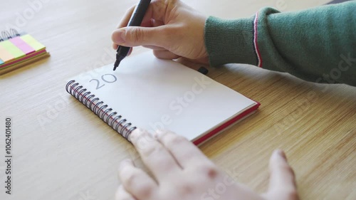 New year's resolutions. Hand writing 2025 text in notebook 