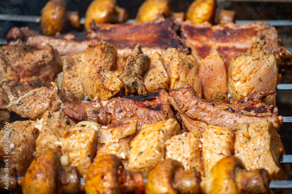 Grilled pieces of pork meat and mushrooms on metal skewers. Shashlik or shish kebab prepared on barbecue grill over hot charcoal with grilled vegetables. Grilled pieces of pork meat and mushrooms on metal skewers. Shashlik or shish kebab prepared on barbecue grill over hot charcoal with grilled vegetables.