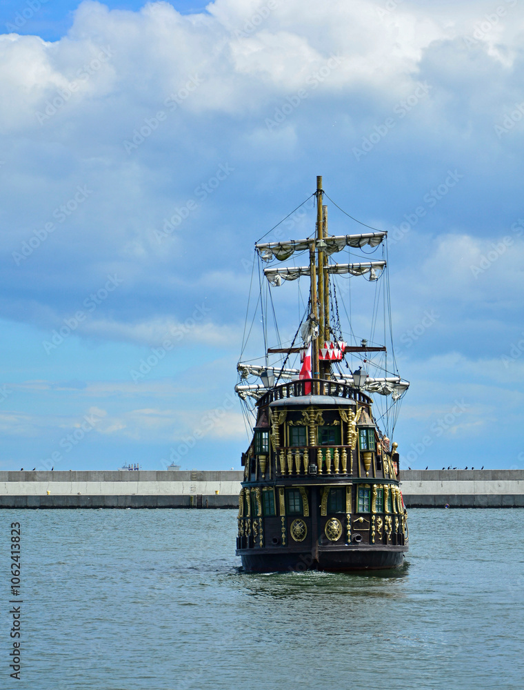 drewniany statek turystyczny ze złotymi dekoracjami, stylizowany piracki statek turystyczny stojący w porcie, wooden tourist ship with golden decorations, golden ancient ship standing in the port