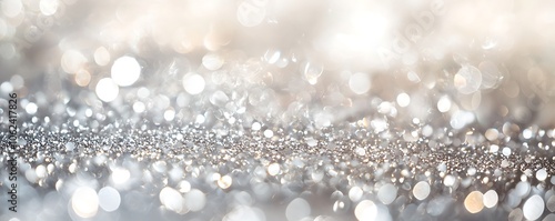 Glittering background in soft pastel silver and white tones, created with a defocused effect.