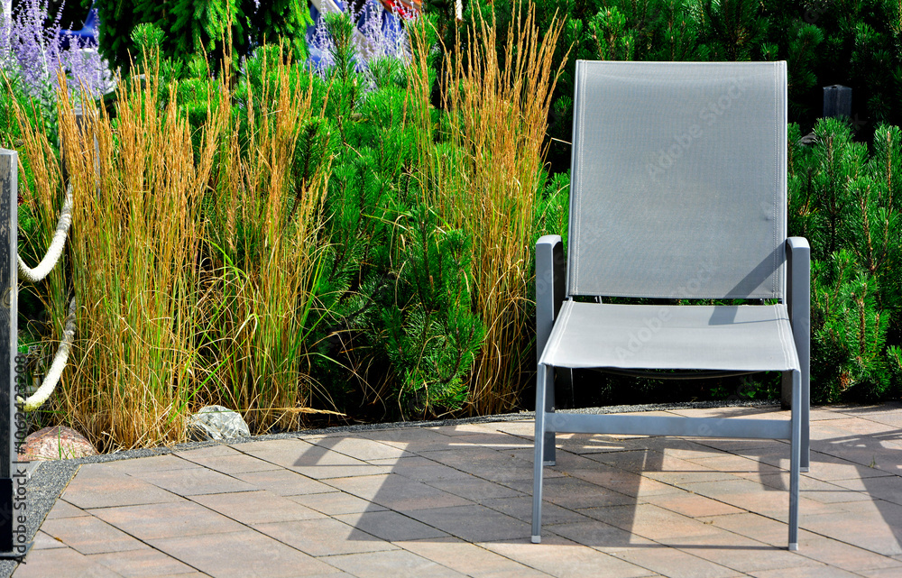 szary leżak w ogrodzie, leżak ogrodowy, puste leżaki ogrodowe, gray deckchair in the garden, garden deckchair, empty garden sunbeds, sitting area