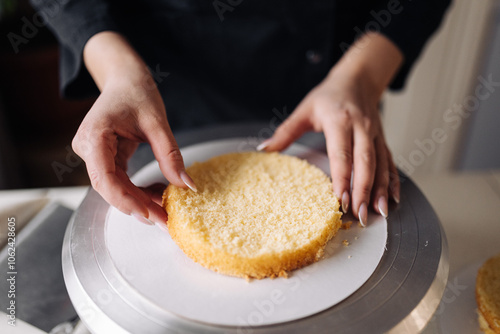 Woman pastry chef spreading cake on baking sheet