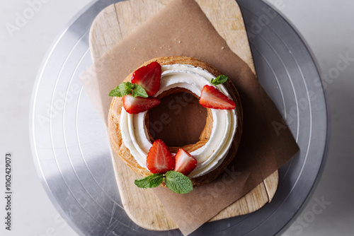 choux pastry creamy cheese cake with mint and strawberries on a craft background