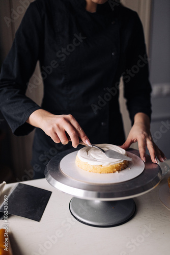 Close up of a woman decorating cake in the kitchen.