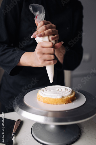 Close up of a woman decorating cake in the kitchen.