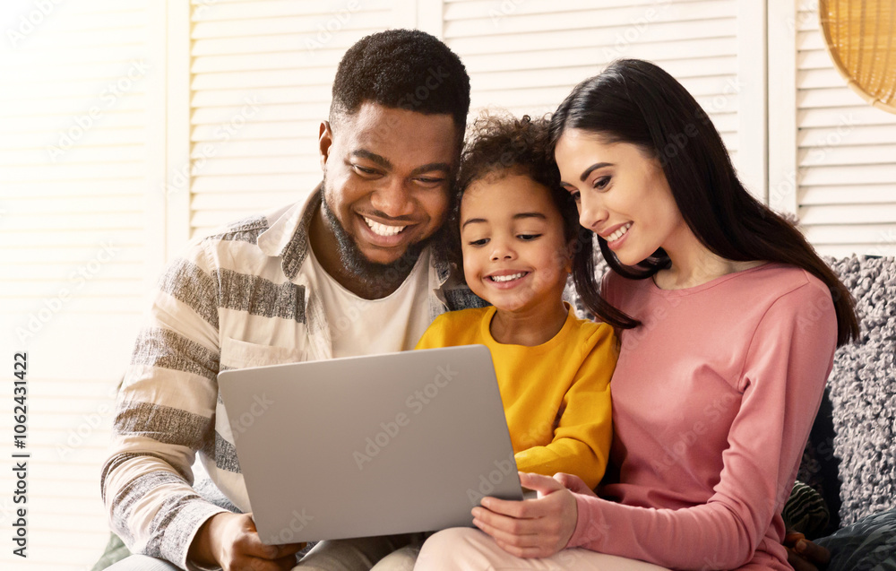Communication on skype. International family with laptop on couch Communication on skype. International family with laptop on couch