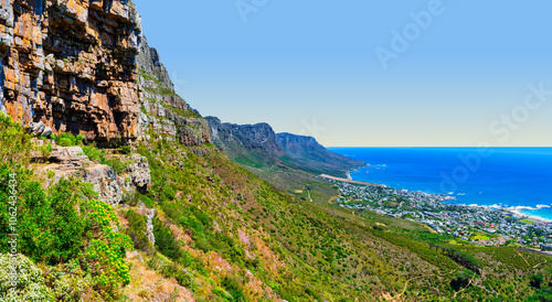 Afternoon scenic view of Bakoven and Camps Bay, with clear blue sky and Twelve Apostles mountains, Cape Town