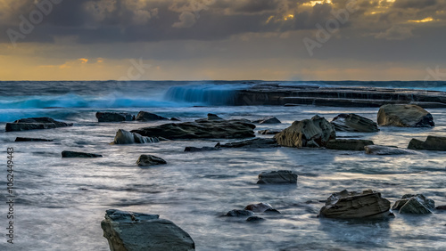 Moody sunrise seascape with clouds at the rocky inlet photo