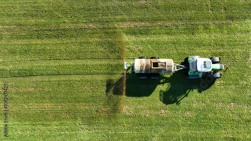 Drohnenaufnahme von einem Traktor der Gülle oder Jauche auf einem Feld ausbreitet
