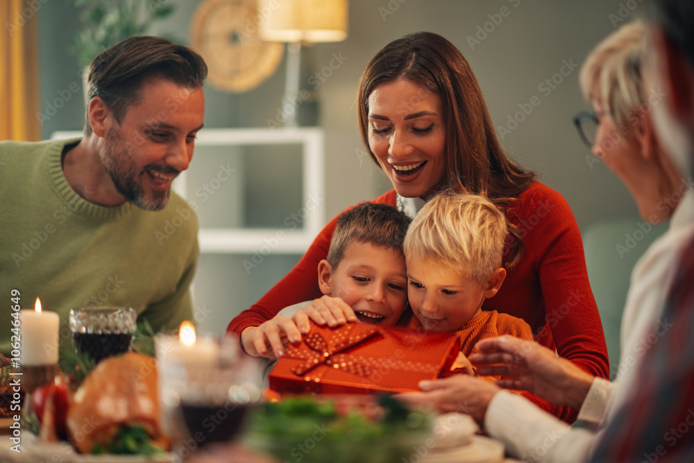 Happy family opening gifts while having christmas dinner Happy family opening gifts while having christmas dinner