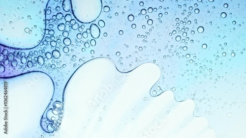 Transparent cosmetic gel fluid with molecule bubbles oil distribution on a white background. Macro Shot of Natural Organic Cosmetics, Medicine. Production Close-up. Slow Motion. High quality 4k 