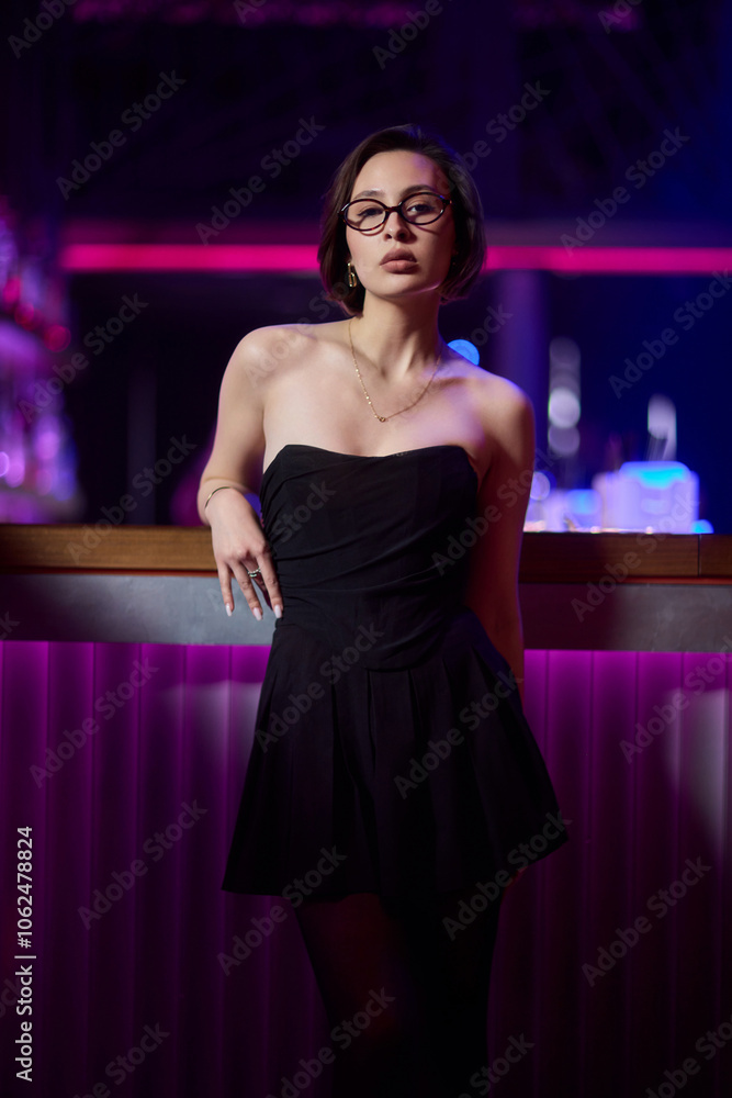 A stylish woman struts into the bar at night, exuding elegance and seduction of nightlife A stylish woman struts into the bar at night, exuding elegance and seduction of nightlife