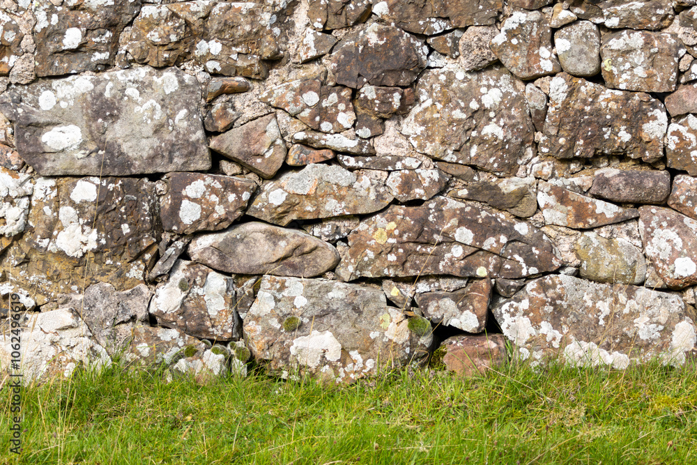A wall made of stone with moss growing on it A wall made of stone with moss growing on it