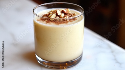 Delicious Homemade Almond Eggnog in Glass on Marble Surface Garnished with Sliced Almonds and Cinnamon for Festive Holiday Beverage and Seasonal Winter Drink