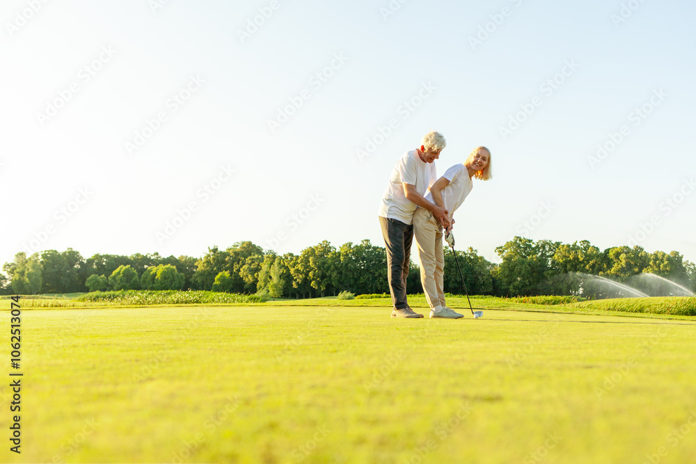 old senior couple in white clothes playing golf on golf course and chatting at sunset, elderly man and woman actively relaxing outdoors and laughing, pensioners on vacation old senior couple in white clothes playing golf on golf course and chatting at sunset, elderly man and woman actively relaxing outdoors and laughing, pensioners on vacation