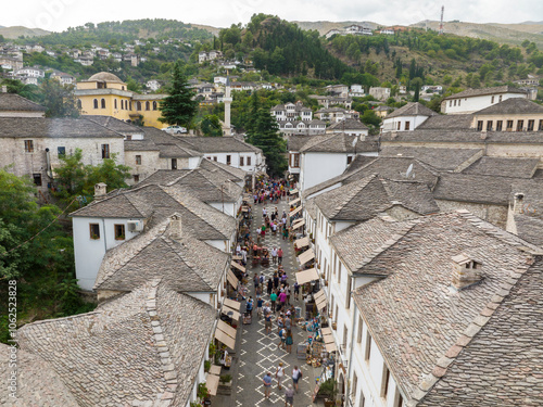 Aerial Top view Drone Shot of the central streets in Gjirokastra, Albania. Crowded Center, Souvenir shop, Cafe, Tourist