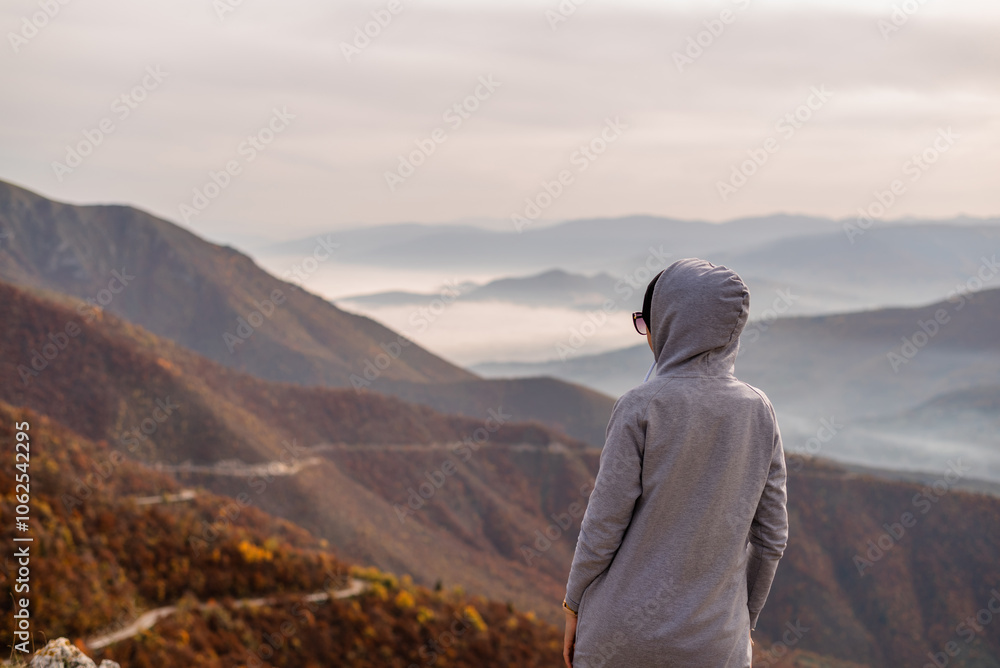 Fototapeta premium A woman traveler enjoys a break look at the top of the mountain.