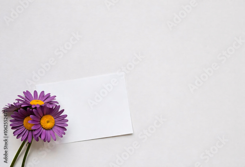 Pink flowers with blank paper on table