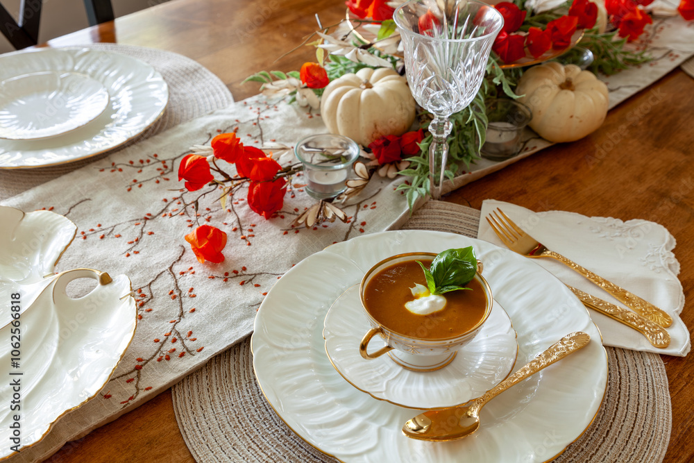 Orange pumpkin and ginger soup served on gold rimmed white fine China plates Orange pumpkin and ginger soup served on gold rimmed white fine China plates
