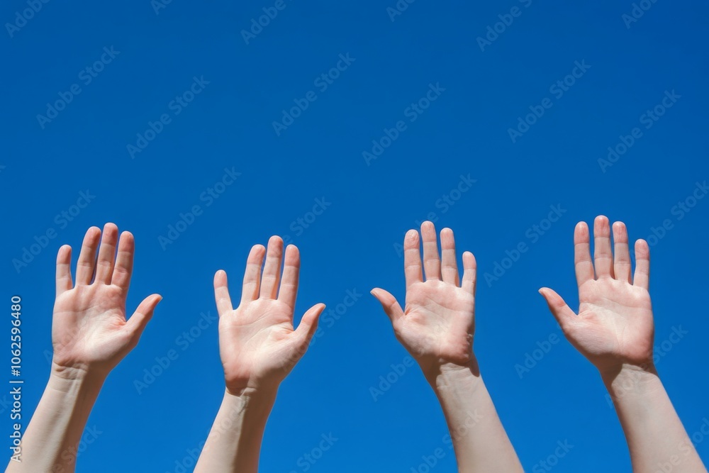 Hands Raised in Unison Against a Clear Blue Sky