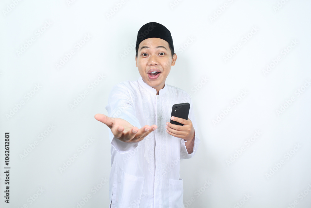 surprised muslim asian man holding mobile phone and raising hand to presenting forward at camera isolated surprised muslim asian man holding mobile phone and raising hand to presenting forward at camera isolated