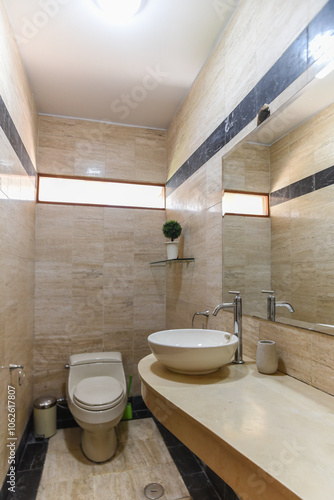 moderno baño de departamento con acabados en loza , lavabo e inodoro , ademas de espejo
