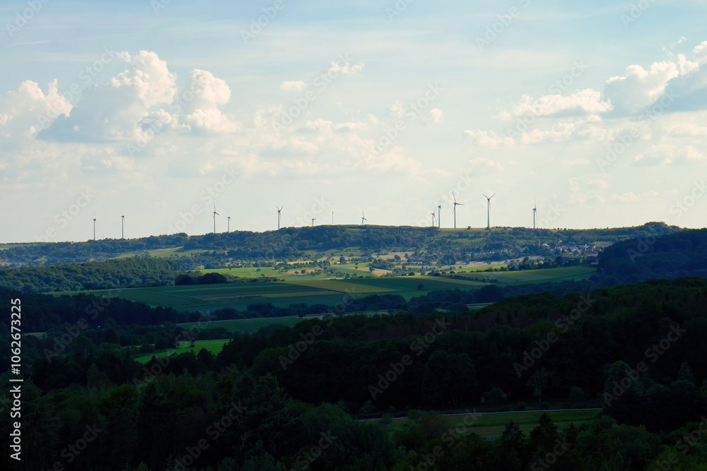 Sun shining on a hill with wind turbines on a spring day in Germany. Sun shining on a hill with wind turbines on a spring day in Germany.