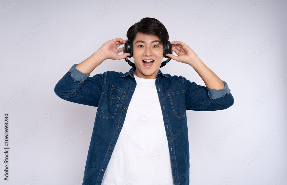 Portrait of a young man wearing headphones and posing on a white background Portrait of a young man wearing headphones and posing on a white background