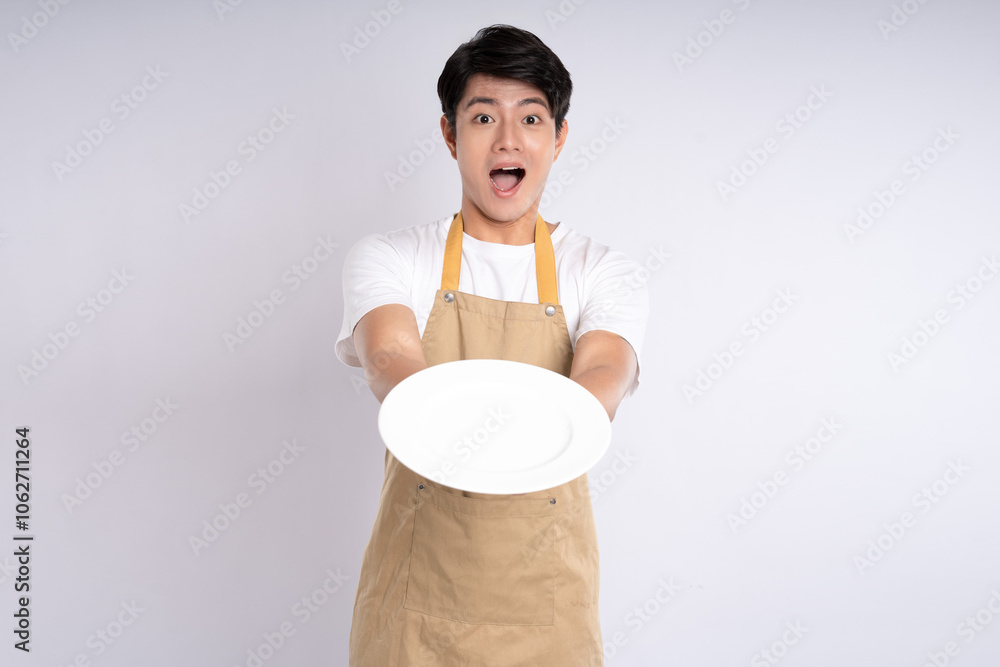 Portrait of young asian man wearing apron and posing on white background Portrait of young asian man wearing apron and posing on white background
