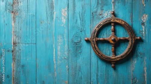 Fototapeta Naklejka Na Ścianę i Meble -  An old wooden ship wheel mounted on a weathered blue wood background.
