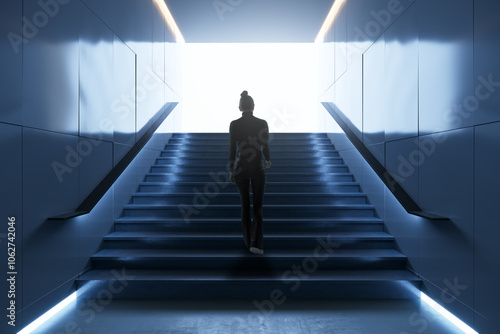 Woman climbing modern stairs in subway with bright background.