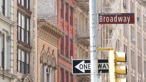 Broadway street road sign, Manhattan midtown property, red brick house architecture, New York City real estate. One way traffic roadsign. Ladies mile historic district, United States.