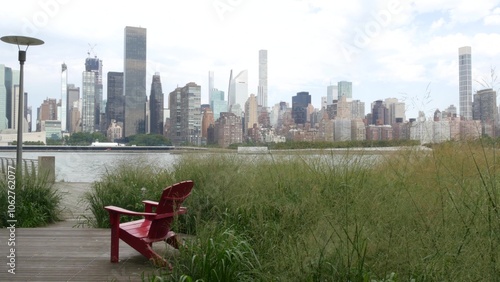 New York City waterfront skyline, Manhattan Midtown buildings, riverfront skyscrapers by East river water. Waterside cityscape view, Gantry Plaza Park, Long Island, Queens. United States. Chair bench. photo