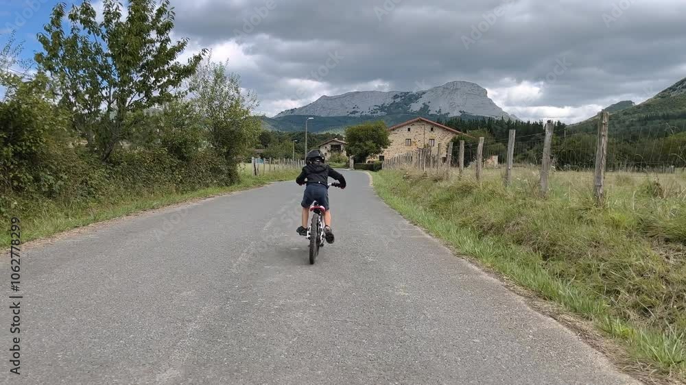A young boy riding his bike through the rural streets of Europe, tracking drone follow shot. A young boy riding his bike through the rural streets of Europe, tracking drone follow shot.