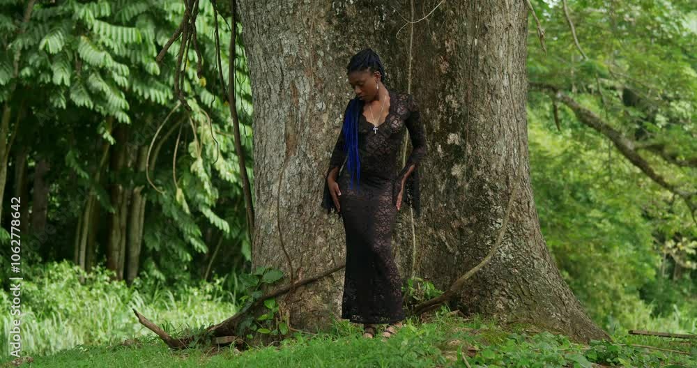 Wearing a sheer lace dress, a Black girl explores a lush tropical park in Trinidad. Wearing a sheer lace dress, a Black girl explores a lush tropical park in Trinidad.